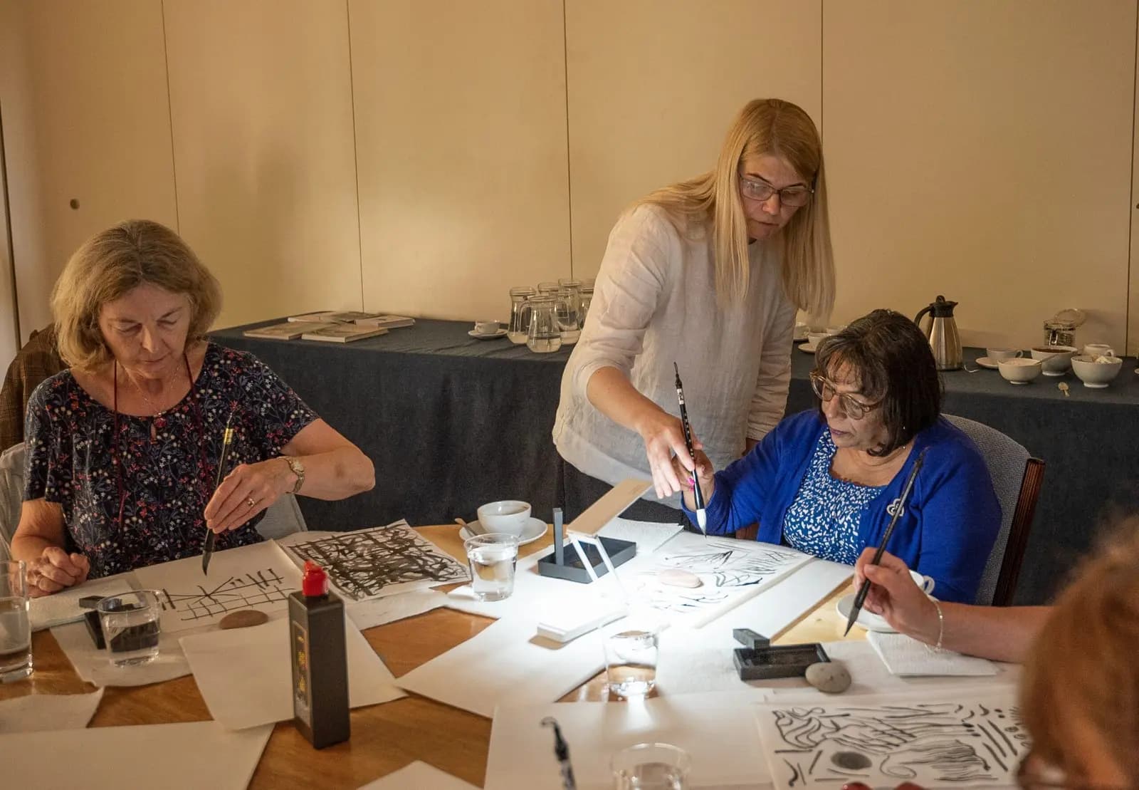 Jurga giving one-to-one brushwork guidance to a student