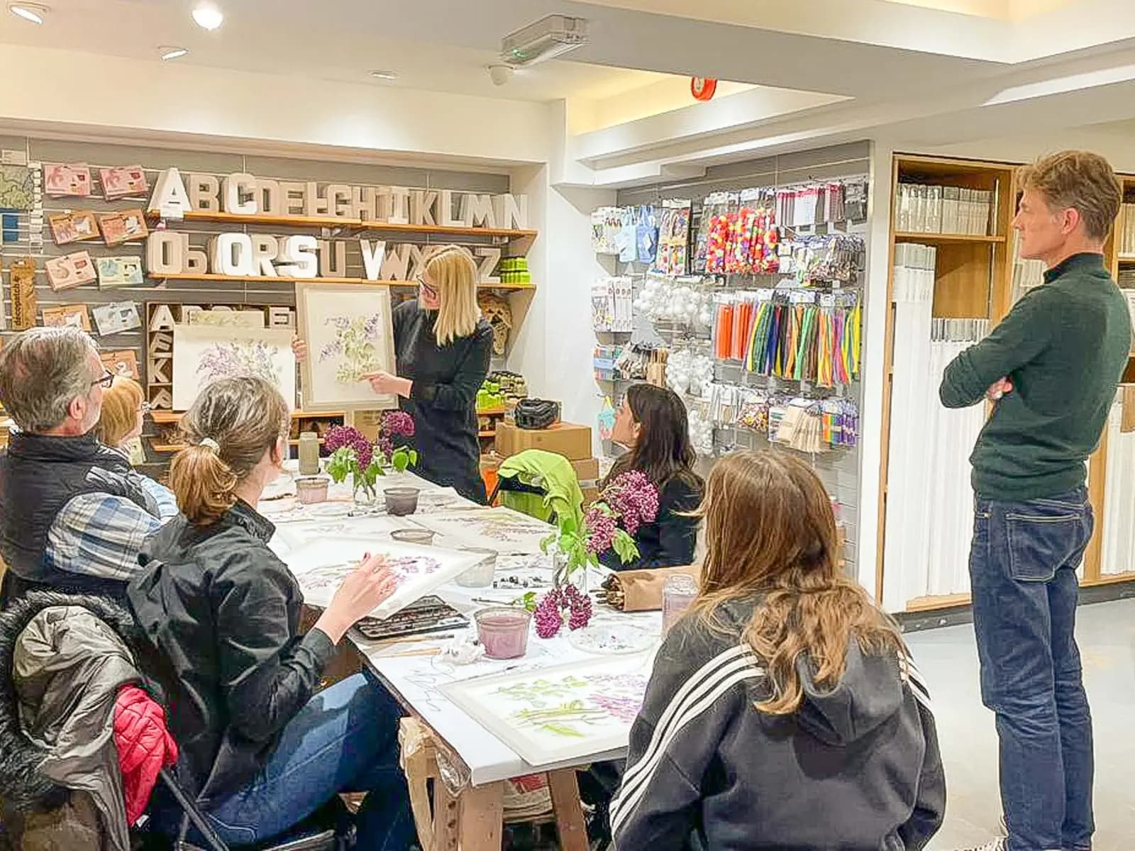 Jurga demonstrating a lilac watercolour painting to her class